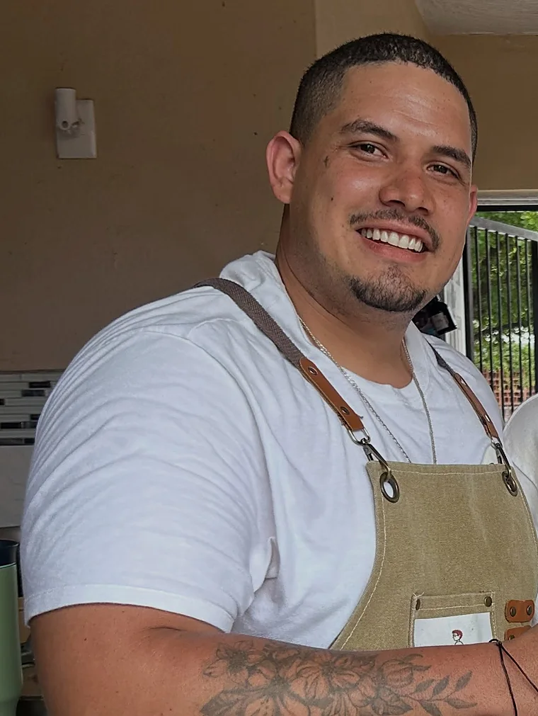 El cocinero de Papú Mar sonriendo en su cocina, con mandil de lona